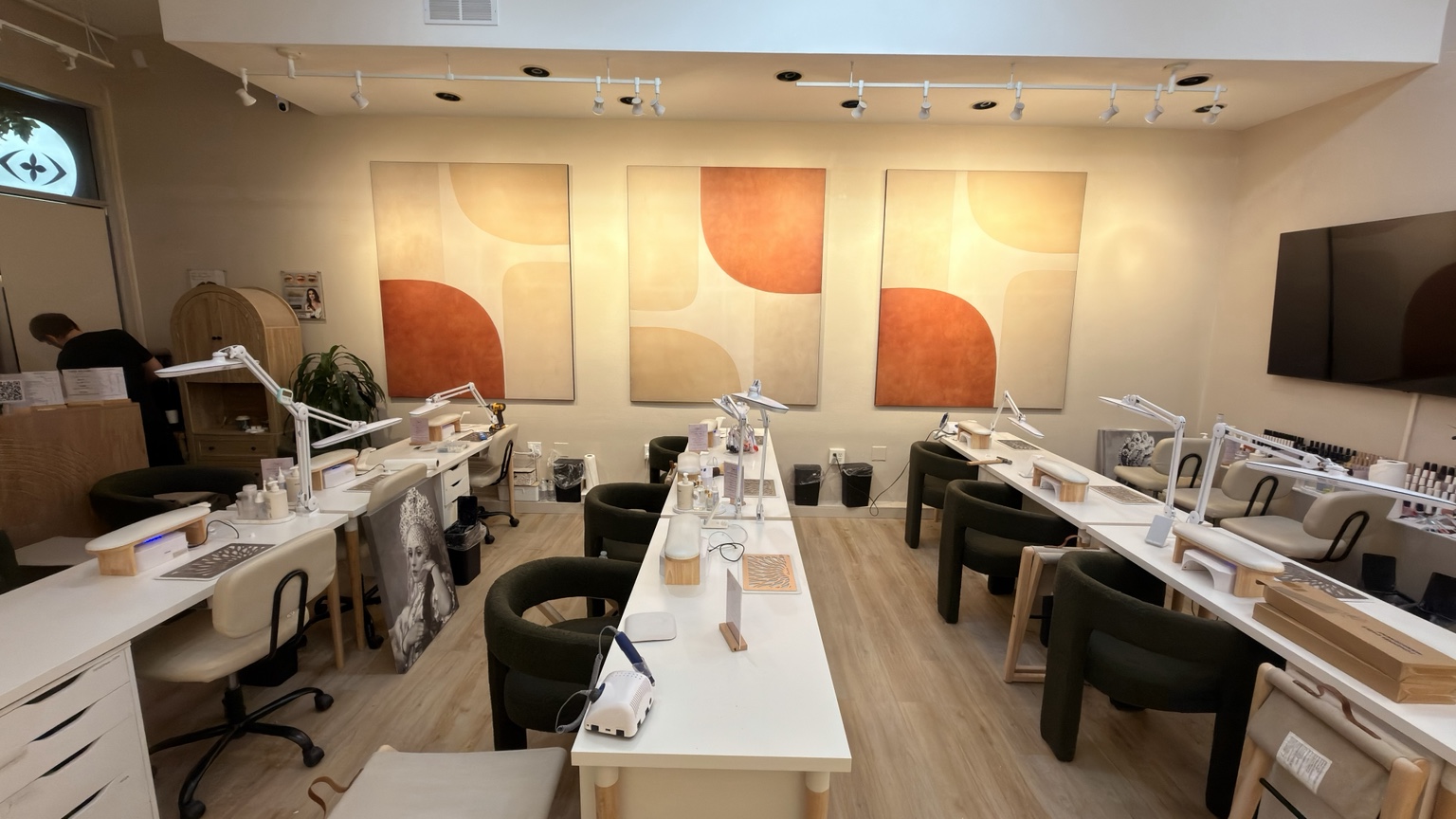 Front view of three orange and cream abstract panels in a nail salon