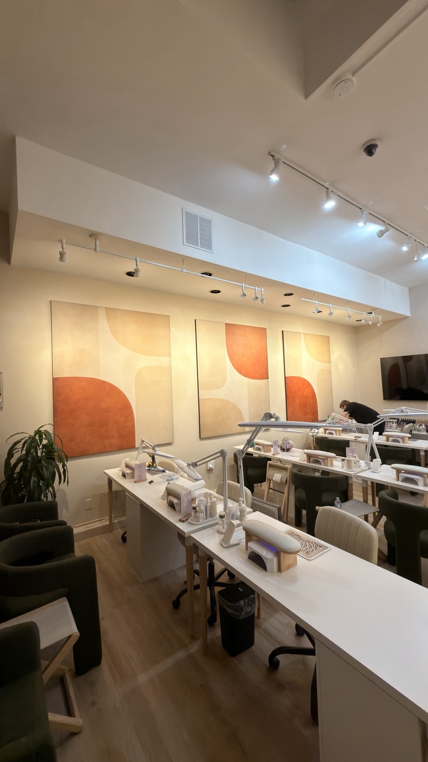 Installed abstract wall art above assembled nail salon workstations
