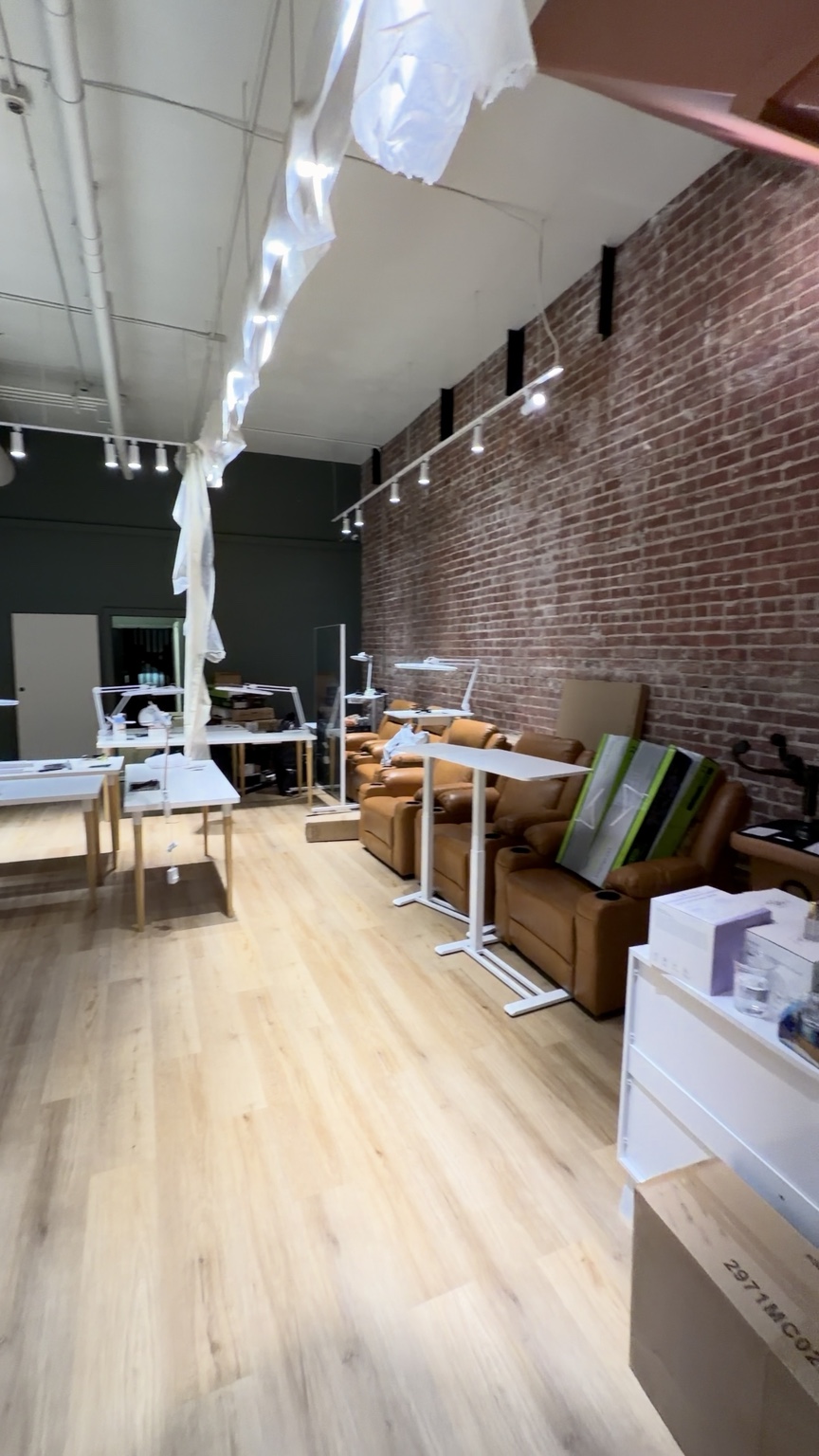 Commercial room with brick wall, new wood-look flooring and furniture