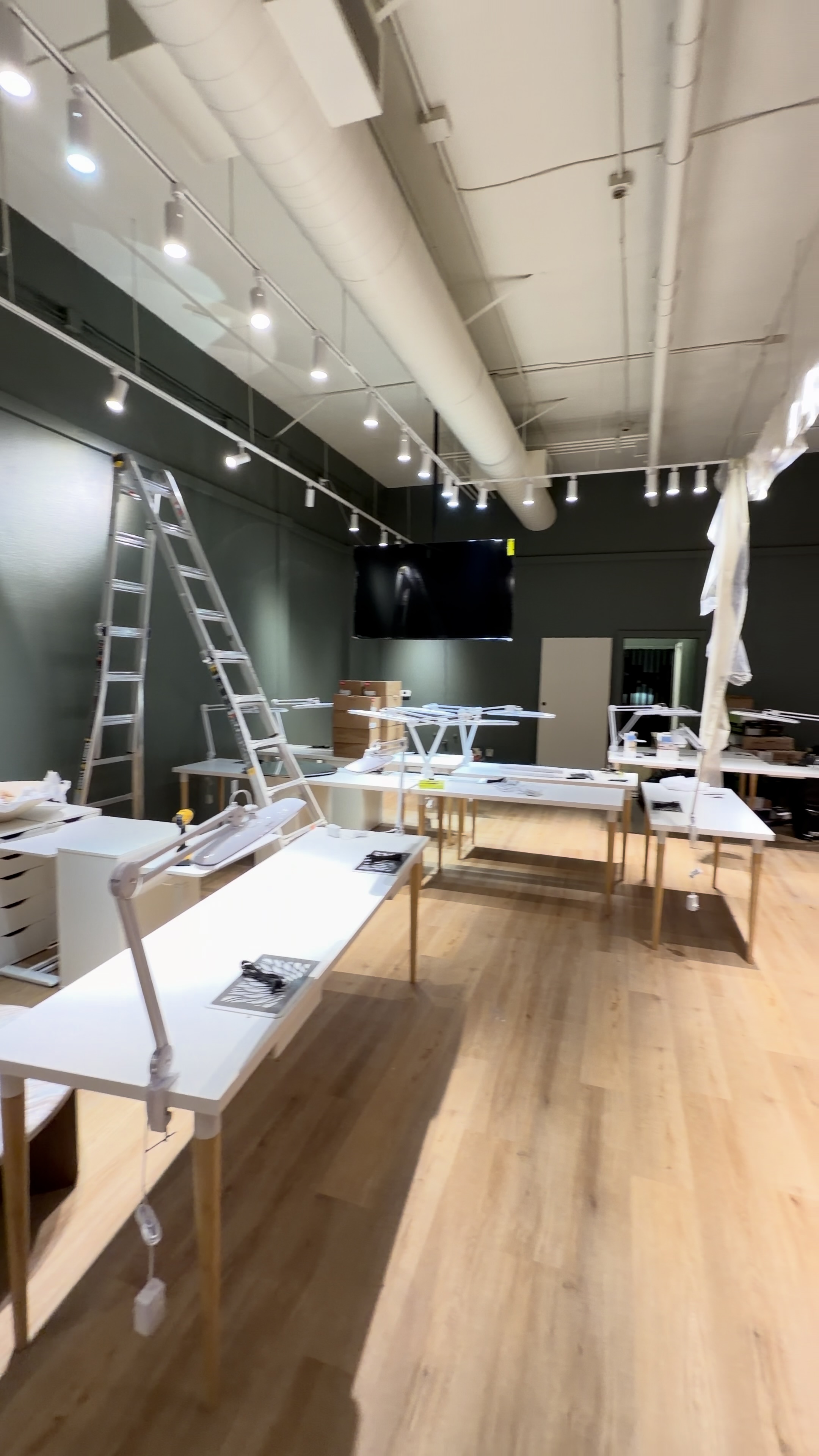 Commercial interior with white ceiling, green walls, workstations and TV
