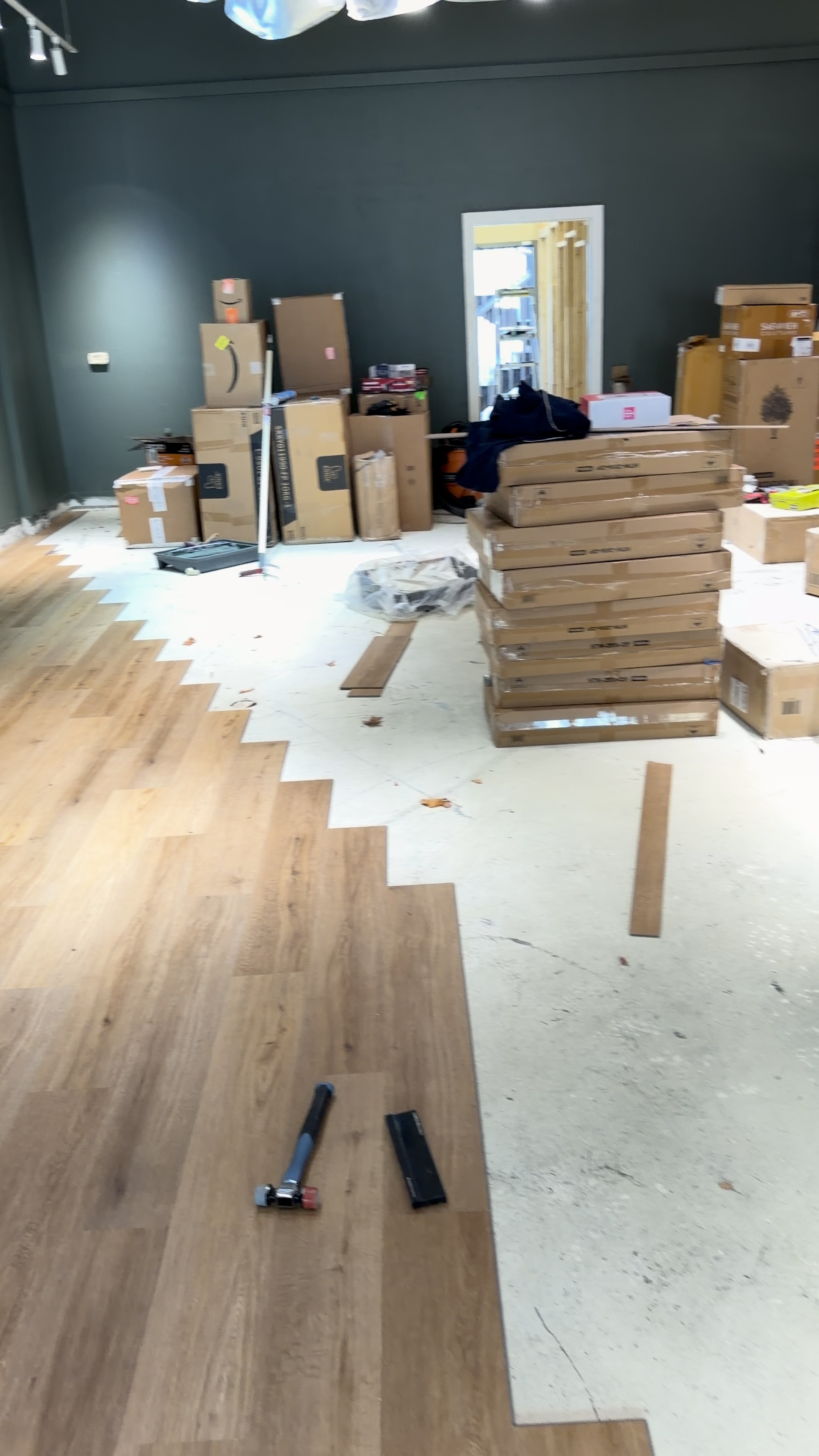Wood-look flooring being installed with tools and materials visible